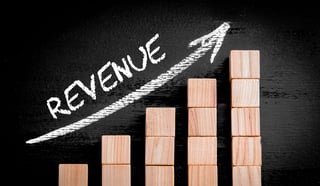 Chart-showing-revenue-growth-with-wood-blocks-and-a-white-arrow-up.