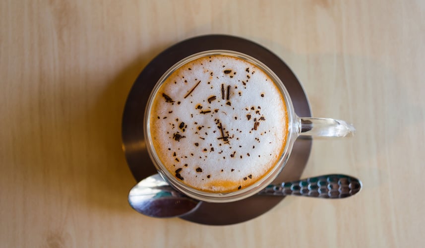 Coffee cup with foam and chocolate sprinkles.