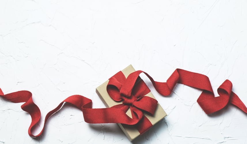Red ribbon tied in a bow on a package.