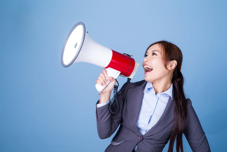 Businesswoman making announcement with megaphone about cross-selling.