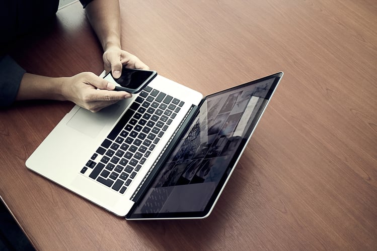 top view of businessman hand working with new modern computer and smart phone and business strategy on wooden desk as concept