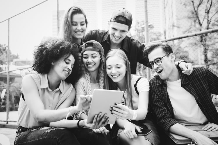 young adults looking at a tablet together